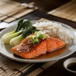 Honey-Soy Glazed Salmon with jasmine rice and baby bok choy on a white plate