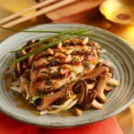 Herb-crusted chicken breasts topped with miso-honey mushroom sauce, crispy pancetta, melted Comté cheese, and garnished with toasted pine nuts and chives.