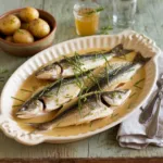 Roasted fish fillets in cider-cream sauce with steamed potatoes, garnished with chives. Easy Cider-Cream Roasted Fish Dinner.