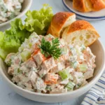 Creamy Classic Carol Chicken Salad with diced chicken, celery, and herbs, served with crisp lettuce leaves and a glass of iced tea.